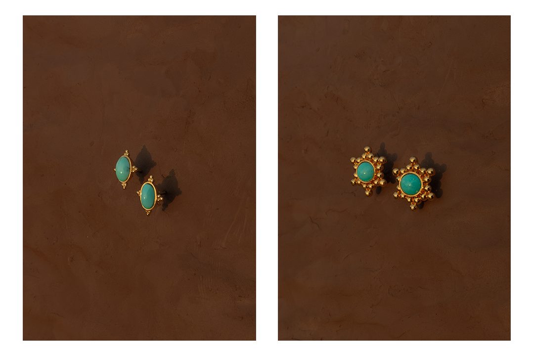 Two pairs of turquoise and gold Alia Bin Omair earrings photographed on clay