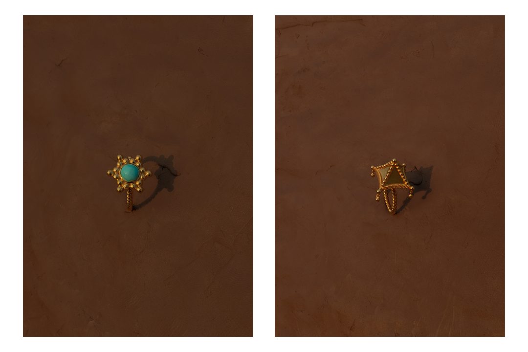 Two Alia Bin Omair rings in turquoise and gold photographed on clay