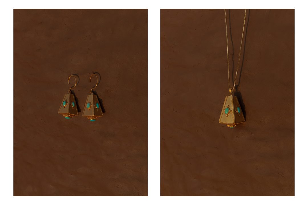 Gold drop earrings set with turquoise, and a pendant on a cord, on clay