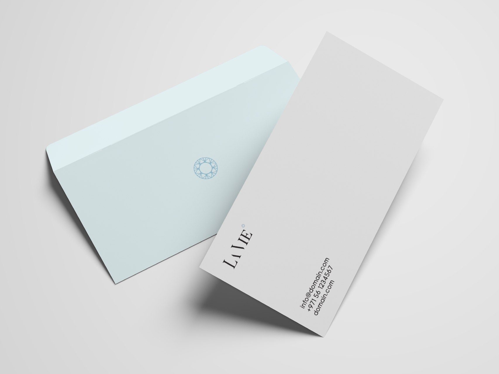 A pale blue envelope with the ornament and a grey card with the La Vie wordmark