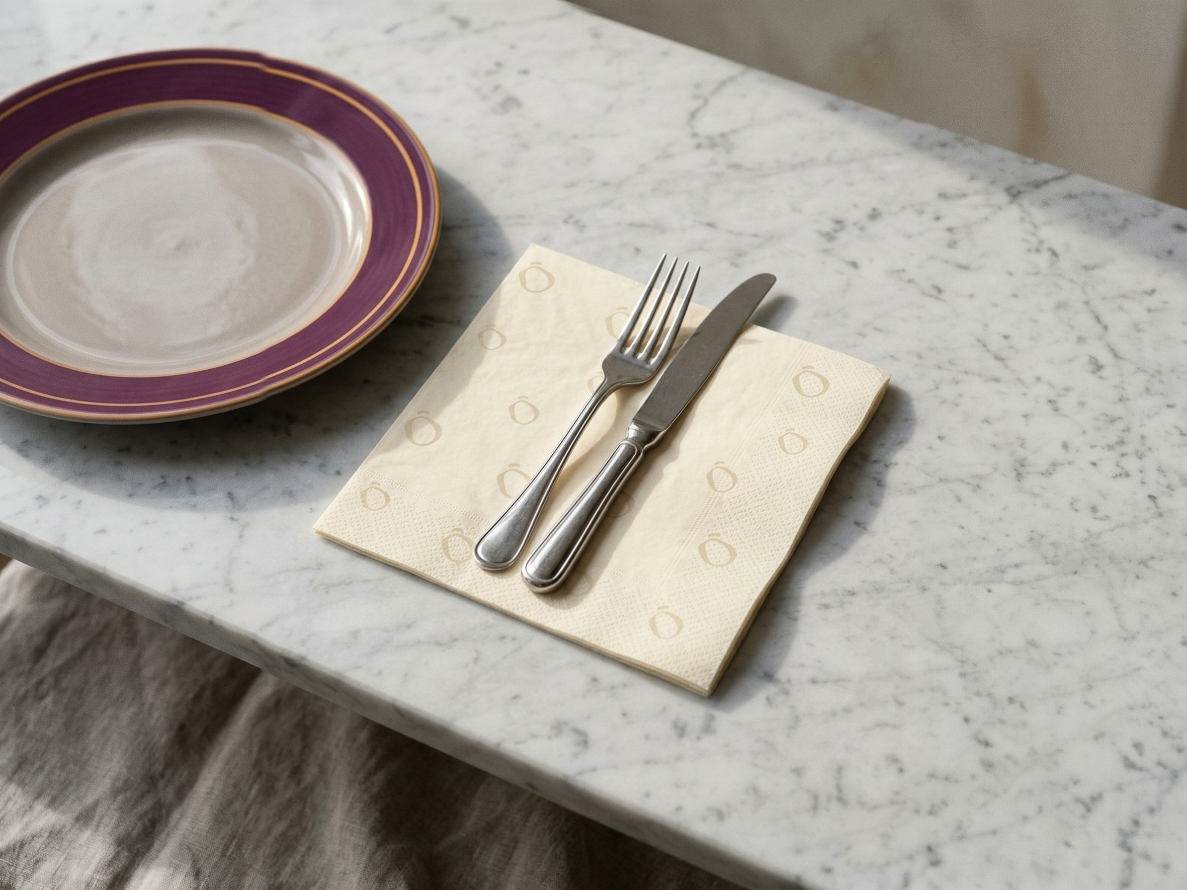 A cream Lento napkin under a knife and fork