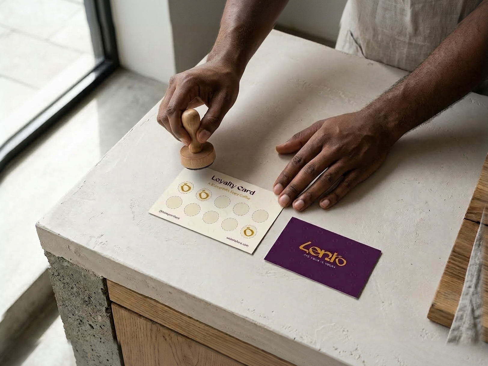 A hand bringing the stamp down on the Lento loyalty card