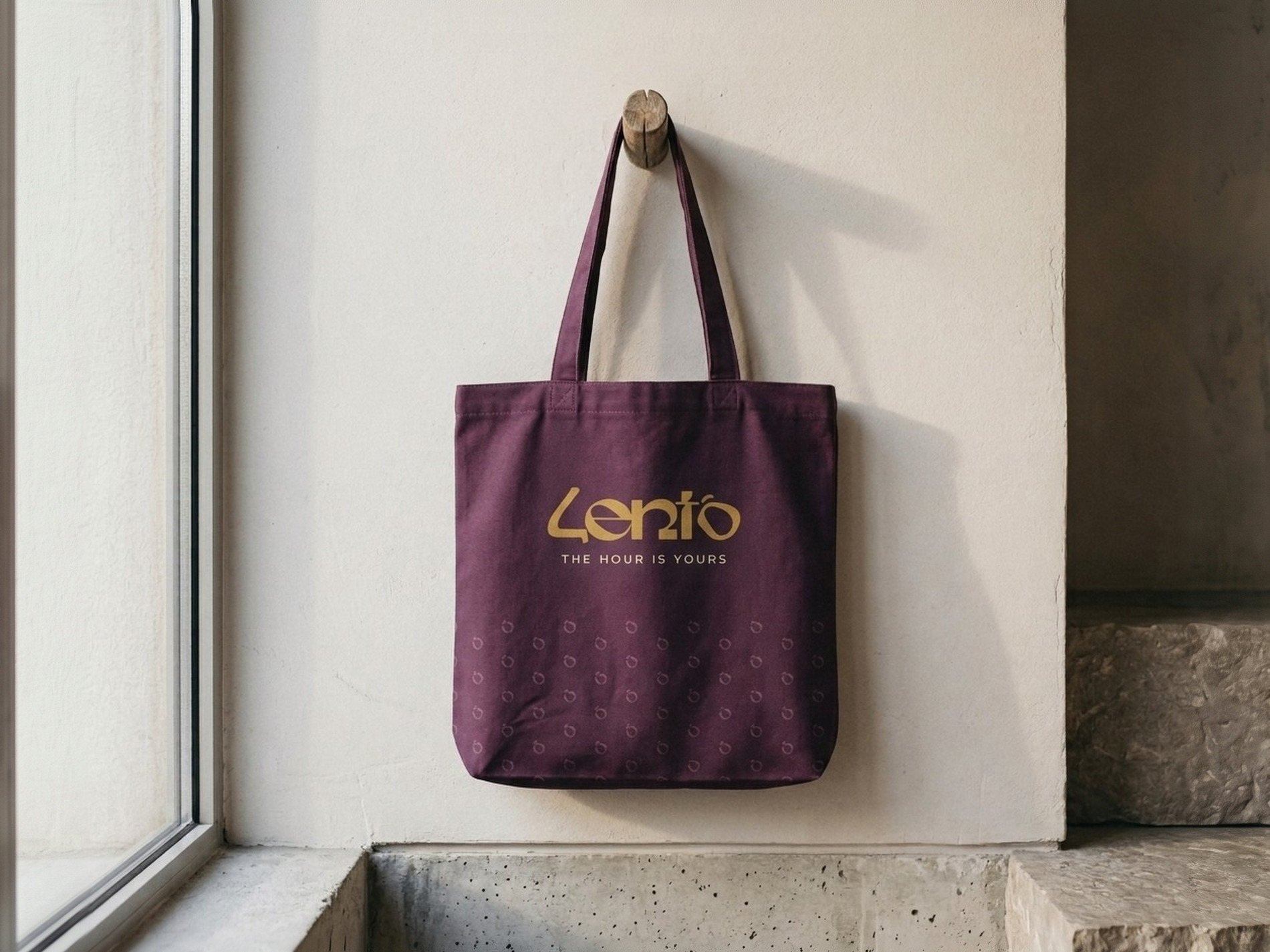 The plum Lento tote bag hanging on a wooden peg