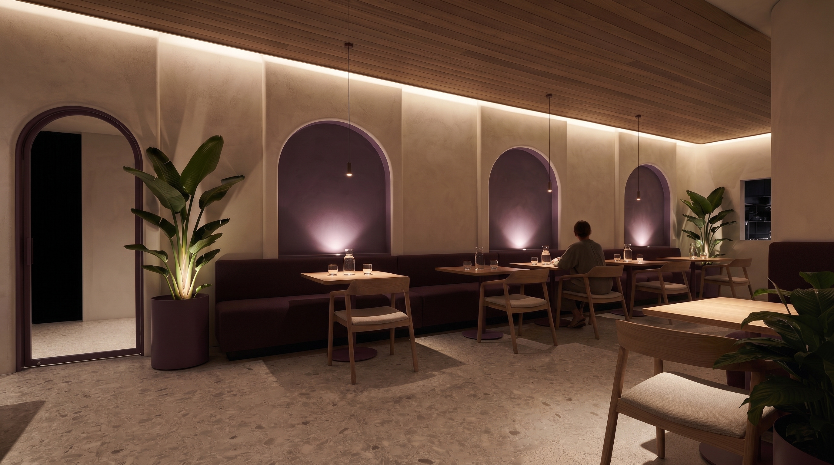 The Lento room at evening: plum niches, pendant pools over the tables, candles lit