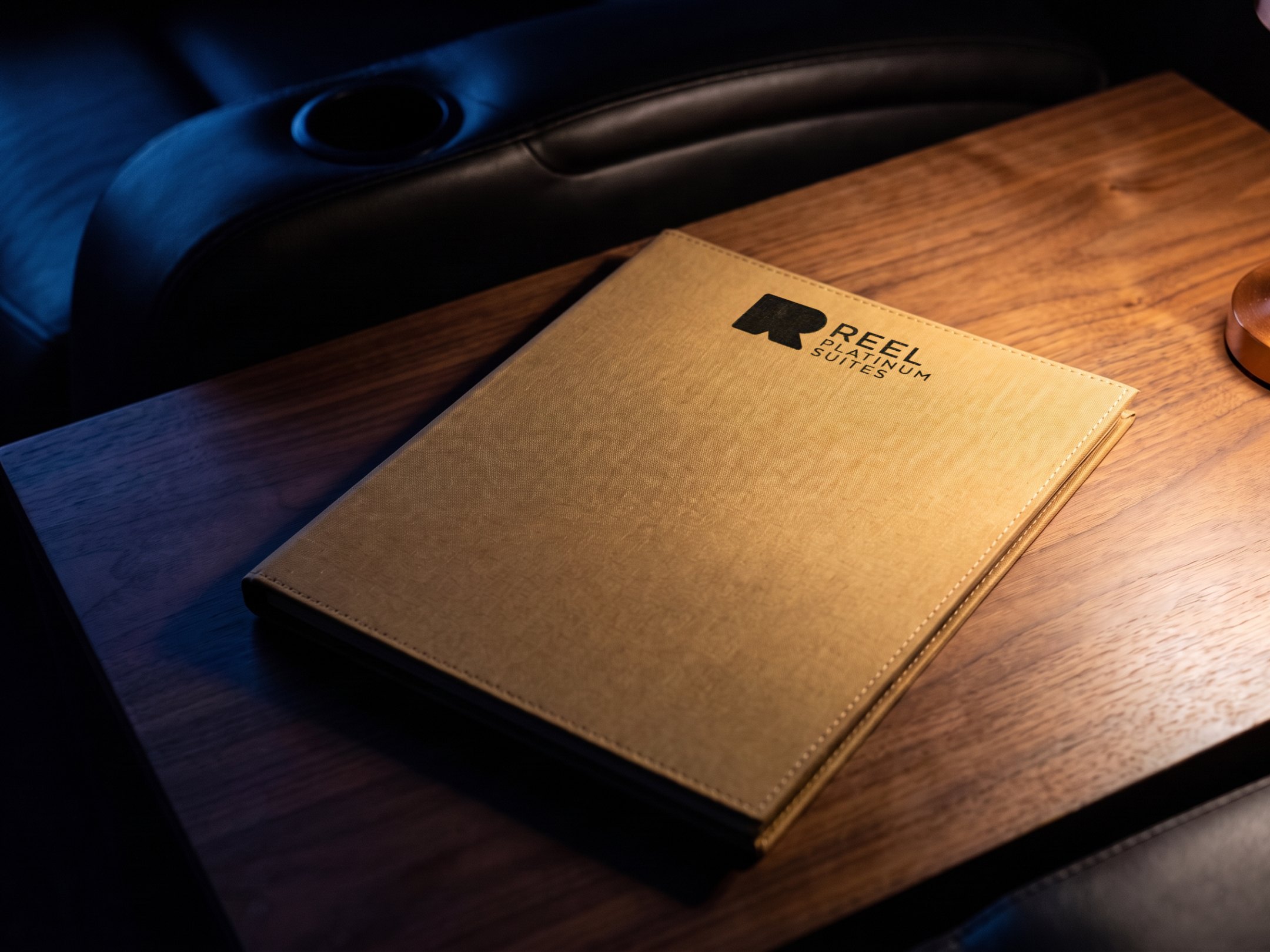A render of the gold linen Reel Platinum Suites menu on a walnut side table
