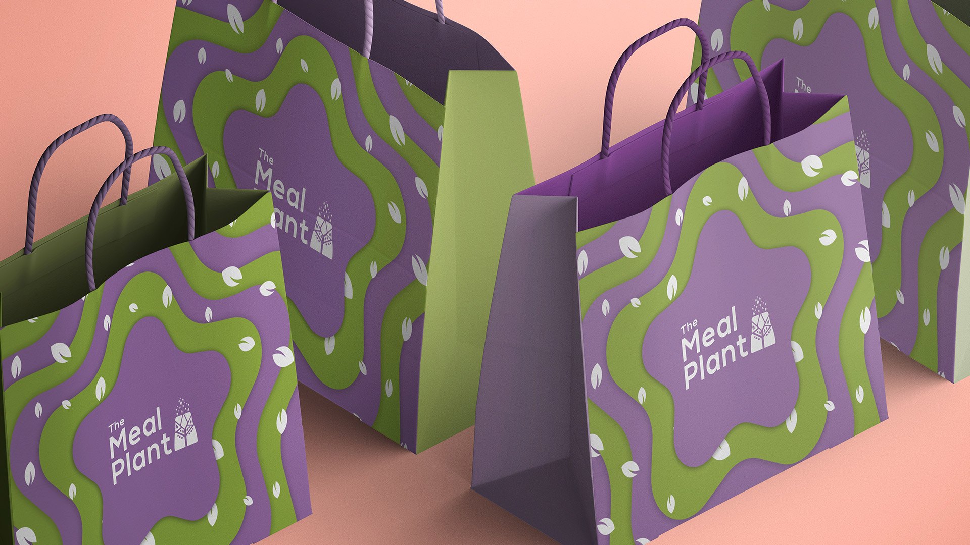 Four paper shopping bags on salmon pink, printed with star rings and the logo
