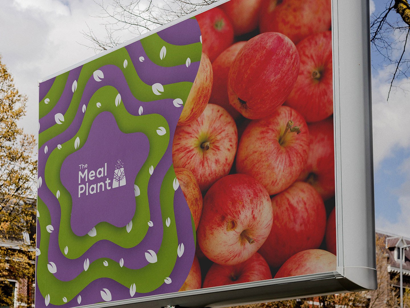 A billboard among autumn trees: the star and logo beside a photograph of apples