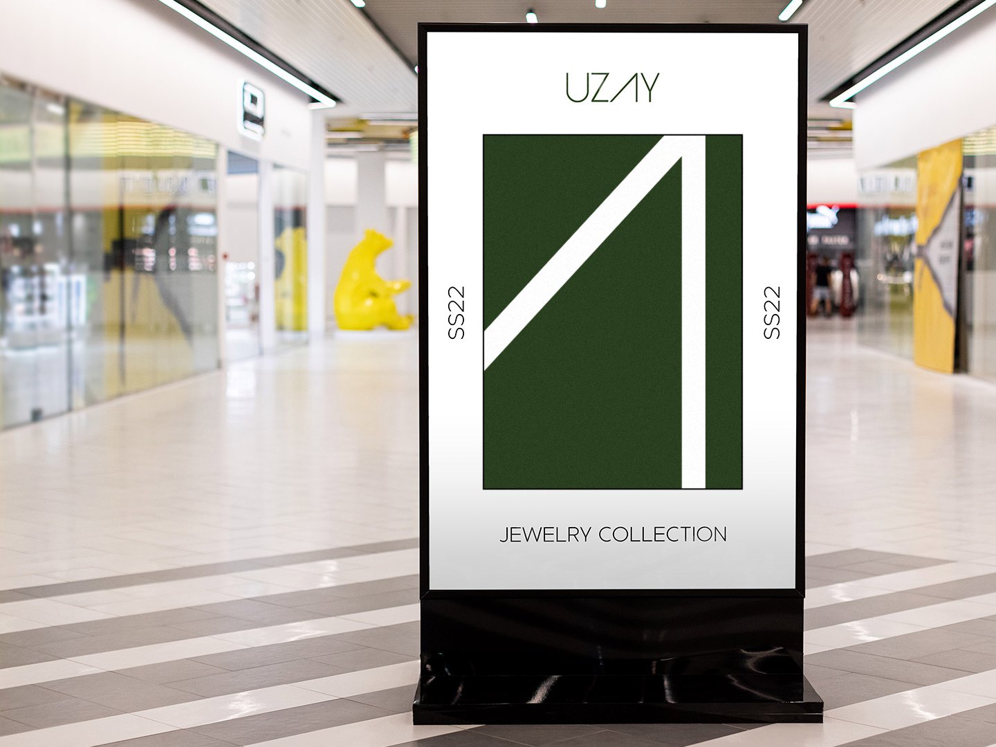 A mall totem carrying an Uzay poster with a large white open A on olive