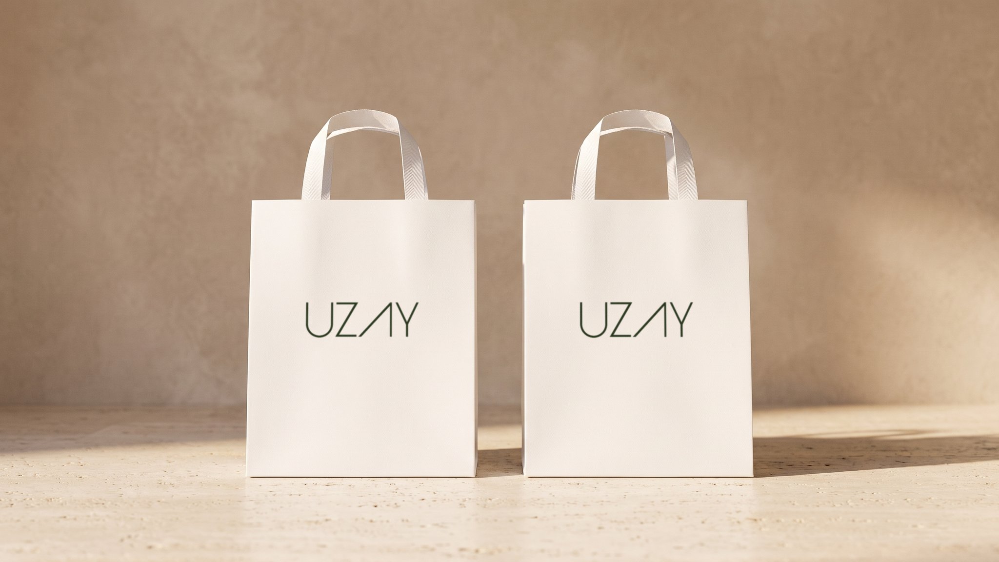 A render: two white paper bags with the Uzay wordmark standing on a travertine floor